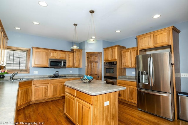 kitchen with a sink, a kitchen island, stainless steel appliances, and dark wood-style flooring