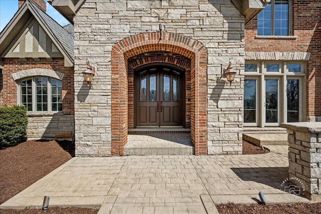 entrance to property with stone siding and brick siding