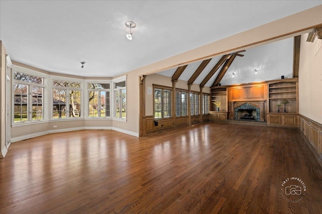 unfurnished living room with wood finished floors, a fireplace with raised hearth, vaulted ceiling with beams, and baseboards