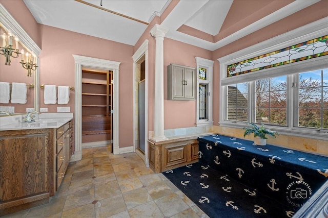 full bathroom featuring vanity, a stall shower, and decorative columns