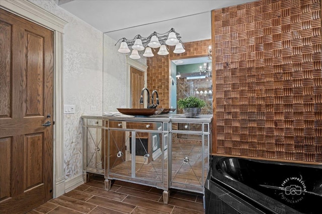 bathroom with a textured wall, tiled bath, vanity, and wood finish floors