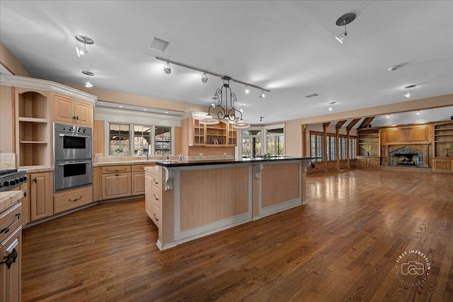 kitchen featuring open shelves, open floor plan, stainless steel double oven, a breakfast bar area, and dark wood-style floors