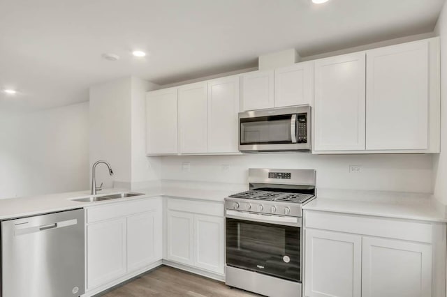 363 Bridgeview Ct, Saint Charles, IL 60174 - kitchen with light wood-style flooring, light countertops, white cabinetry, stainless steel appliances, and a sink