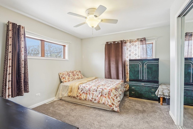 bedroom with a ceiling fan, carpet flooring, and baseboards