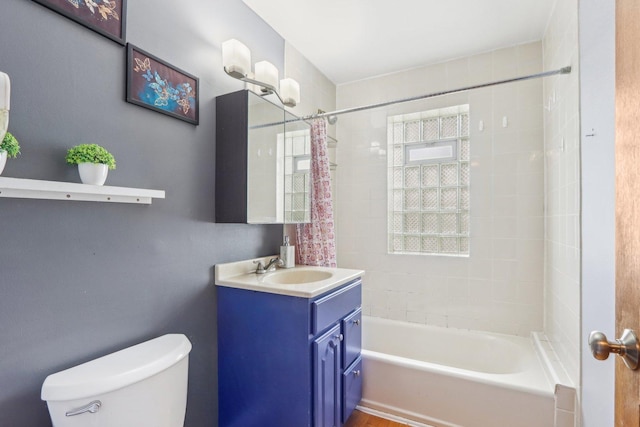 bathroom featuring shower / bathtub combination with curtain, toilet, and vanity