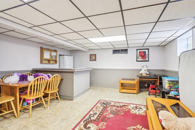 playroom with tile patterned floors and a paneled ceiling
