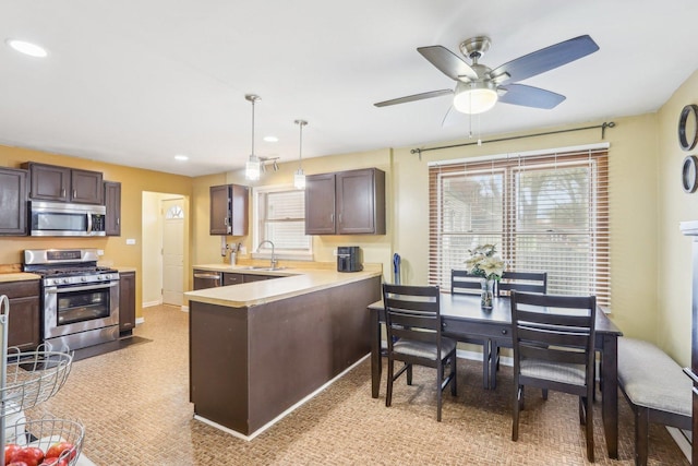 kitchen with a healthy amount of sunlight, stainless steel appliances, light countertops, and a sink