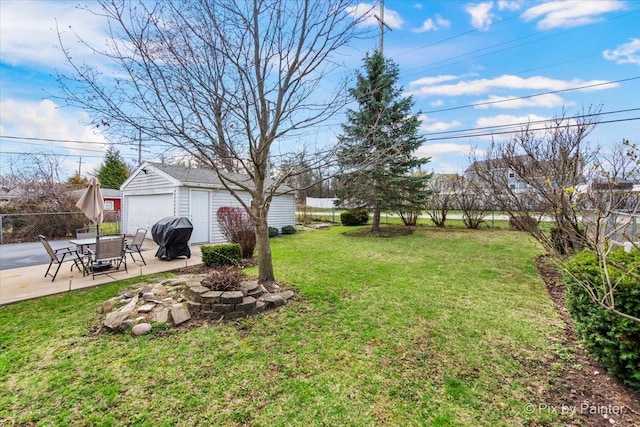 view of yard with fence, a patio area, an outdoor structure, and a detached garage