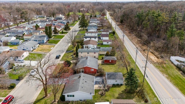 drone / aerial view featuring a residential view and a wooded view