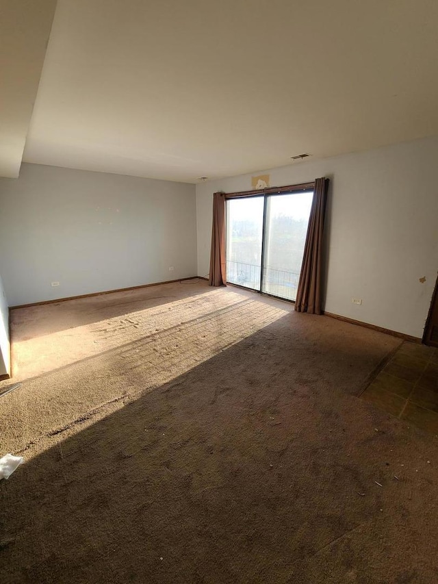 spare room with carpet, visible vents, and baseboards