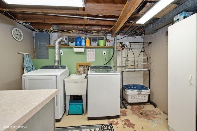 clothes washing area with electric panel, washing machine and dryer, and laundry area