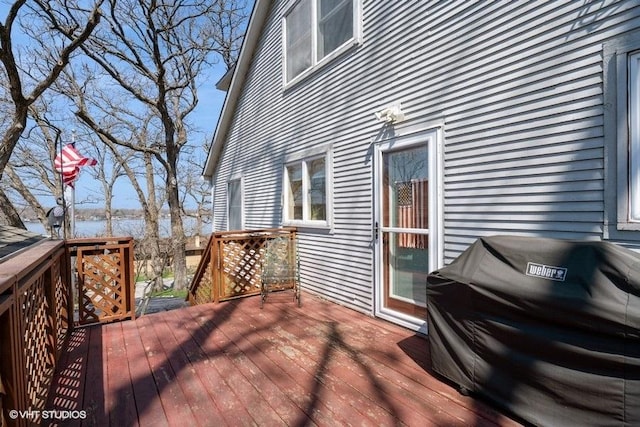 wooden deck with a water view and area for grilling