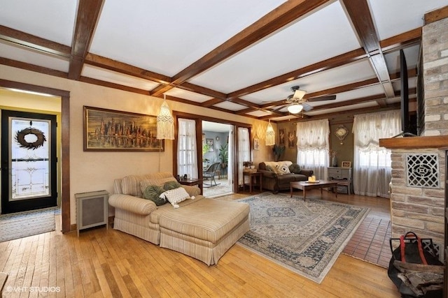 living area featuring beam ceiling, ceiling fan, wood-type flooring, and coffered ceiling
