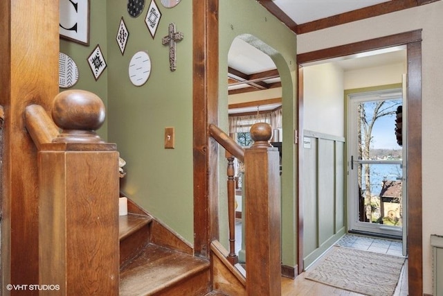 foyer with arched walkways and beam ceiling