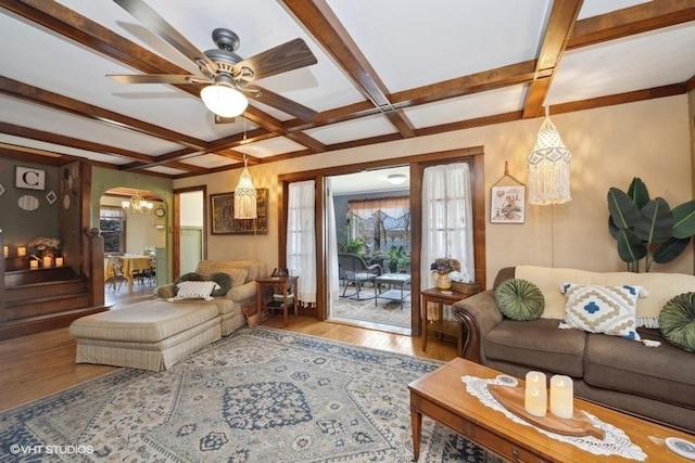 living room featuring coffered ceiling, wood finished floors, beamed ceiling, and ceiling fan with notable chandelier