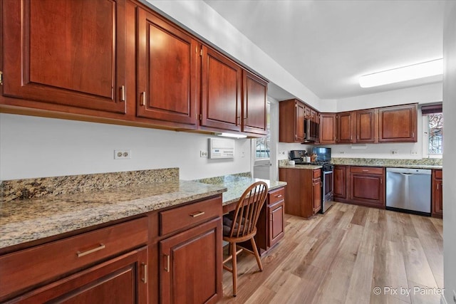 kitchen featuring light stone countertops, light wood-style floors, and appliances with stainless steel finishes