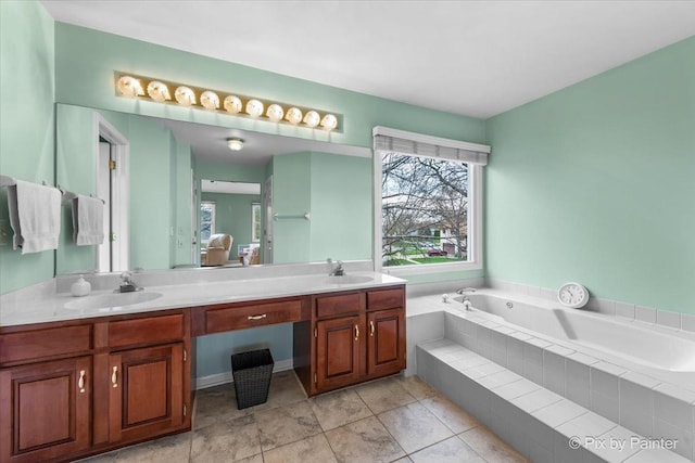 bathroom with a garden tub, tile patterned floors, a sink, and double vanity