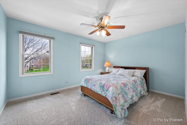 bedroom with baseboards, visible vents, carpet flooring, and ceiling fan