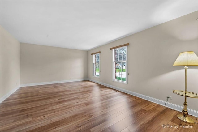 unfurnished room featuring baseboards and wood finished floors