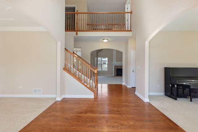 1866 Snead St, Bolingbrook, IL 60490 - foyer featuring a towering ceiling, visible vents, arched walkways, a tile fireplace, and stairs