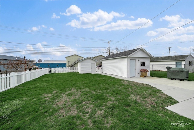 view of yard featuring a storage unit, a fenced backyard, and an outbuilding
