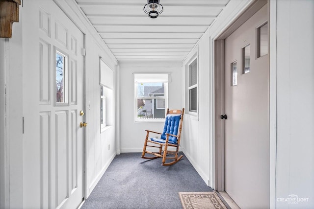 hallway with carpet floors and baseboards