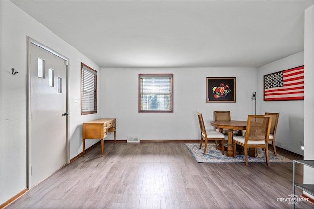 dining space with visible vents, baseboards, and wood finished floors