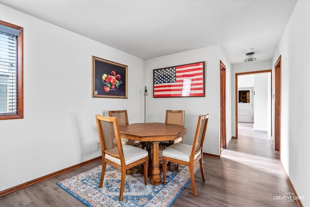 dining space featuring baseboards and wood finished floors
