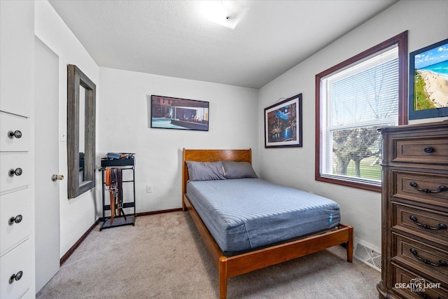 bedroom featuring light colored carpet and baseboards