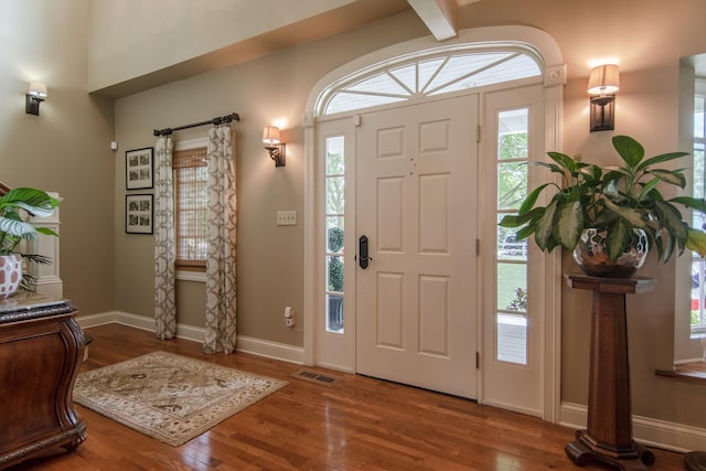 foyer entrance with wood finished floors, visible vents, and baseboards