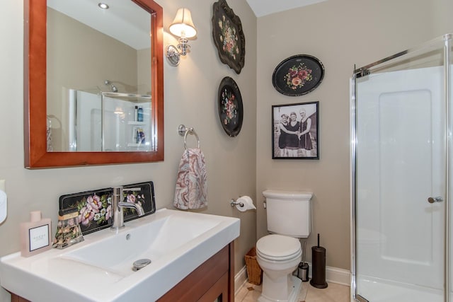 full bathroom featuring toilet, vanity, a shower stall, and baseboards