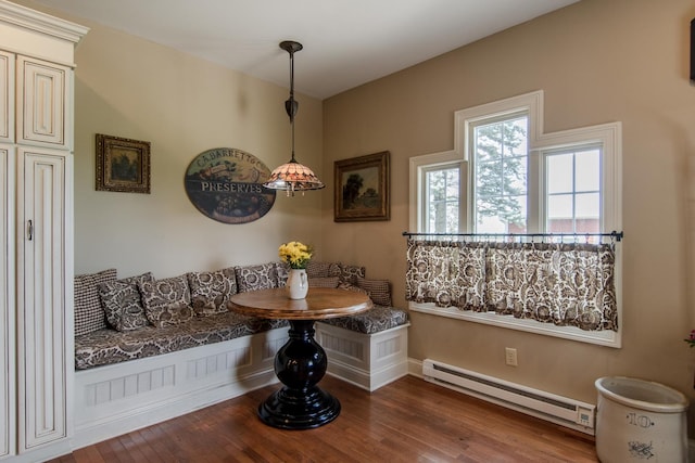 dining room featuring baseboards, wood finished floors, and a baseboard radiator