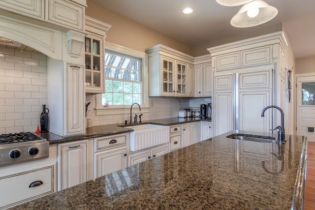 kitchen featuring backsplash, a sink, and stainless steel gas stovetop