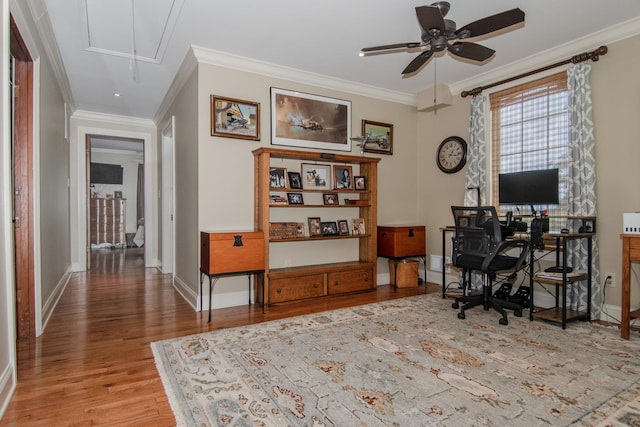 office space with attic access, ceiling fan, wood finished floors, and crown molding
