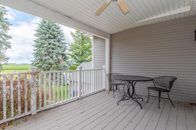 wooden deck with a ceiling fan and outdoor dining space