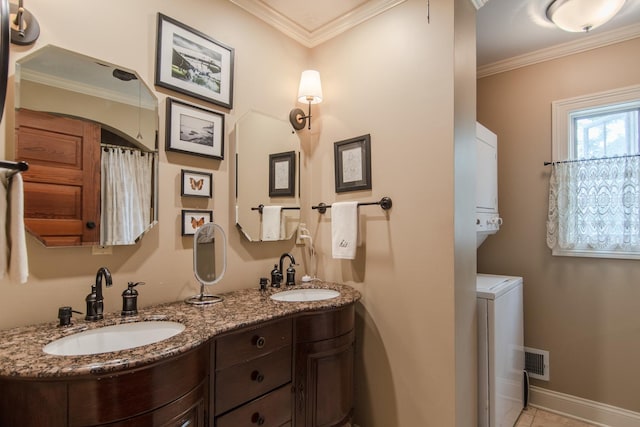 bathroom with visible vents, stacked washer / dryer, baseboards, and a sink