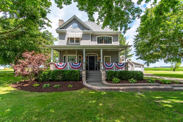 view of front of house with covered porch, a garage, a chimney, and a front lawn