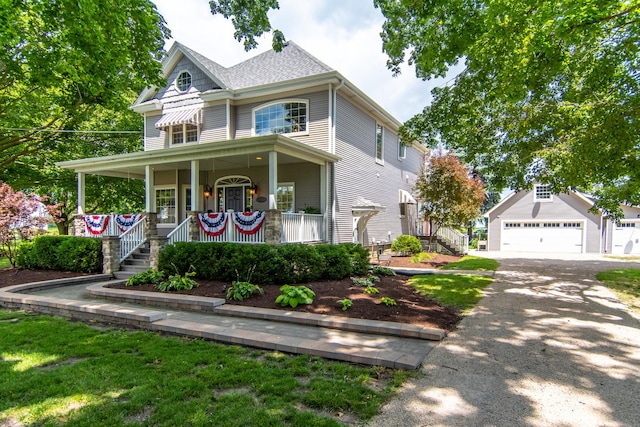 victorian home featuring a porch, an outdoor structure, stairs, and driveway