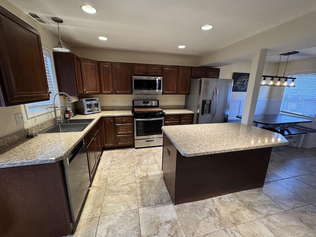 800 Tomahawk Trl, Round Lake Heights, IL 60073 - kitchen with a center island, decorative light fixtures, a sink, dark brown cabinets, and stainless steel appliances