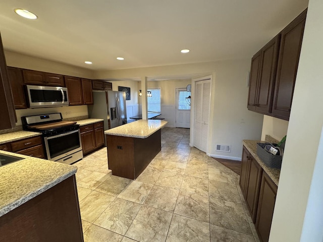 800 Tomahawk Trl, Round Lake Heights, IL 60073 - kitchen with recessed lighting, a center island, dark brown cabinets, visible vents, and stainless steel appliances