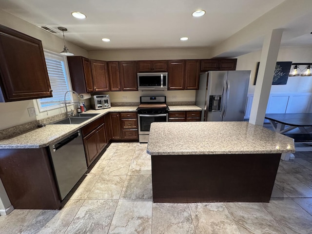 800 Tomahawk Trl, Round Lake Heights, IL 60073 - kitchen featuring a center island, decorative light fixtures, a sink, dark brown cabinets, and stainless steel appliances