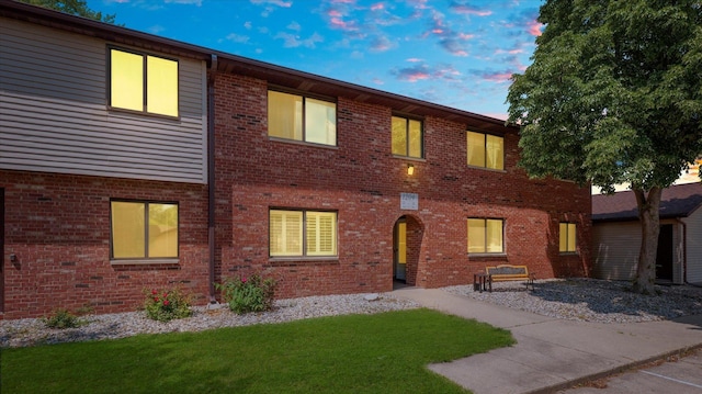 view of front of home with brick siding and a front yard