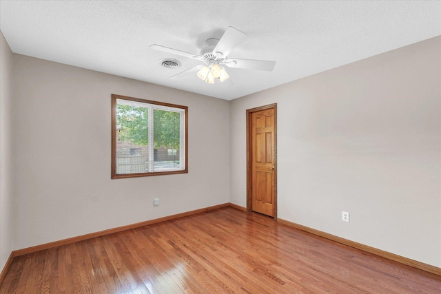 empty room with light wood finished floors, baseboards, and a ceiling fan