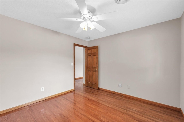 empty room featuring light wood-style flooring, baseboards, and ceiling fan