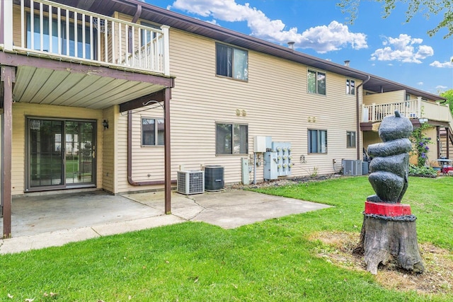 rear view of house featuring a yard, a patio, central air condition unit, and a balcony