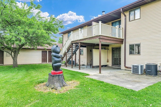 rear view of house with cooling unit, a patio area, a lawn, and stairway