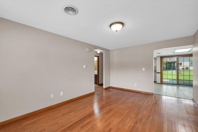 spare room featuring light wood-style flooring and baseboards