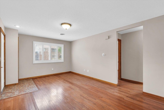 unfurnished room with light wood-style floors and baseboards
