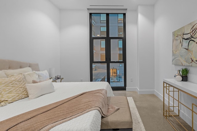bedroom with concrete floors and baseboards