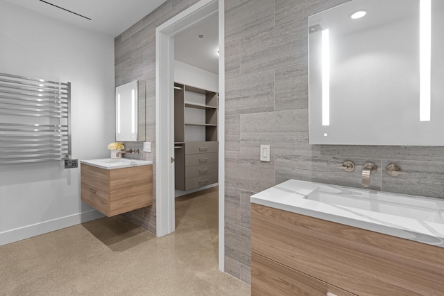 full bathroom featuring tile walls, radiator, vanity, and baseboards